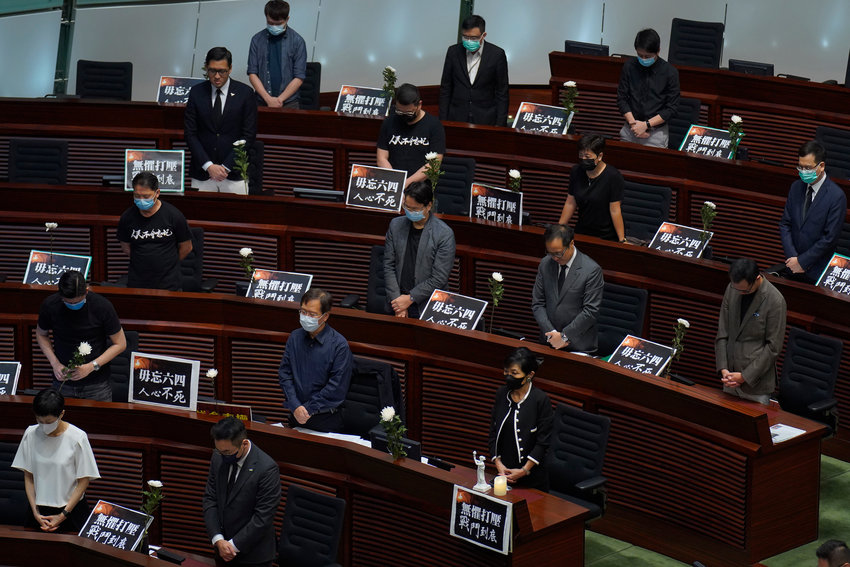 Pan-democratic legislators pay one minute of silence for the 31st anniversary of Tiananmen crackdown before a Legislative Council meeting to debate national anthem bill in Hong Kong, Thursday, June 4, 2020. On anniversary of Tiananmen crackdown, Hong Kong continued debating a contentious law that makes it illegal to insult or abuse the Chinese national anthem. (AP Photo/Vincent Yu).