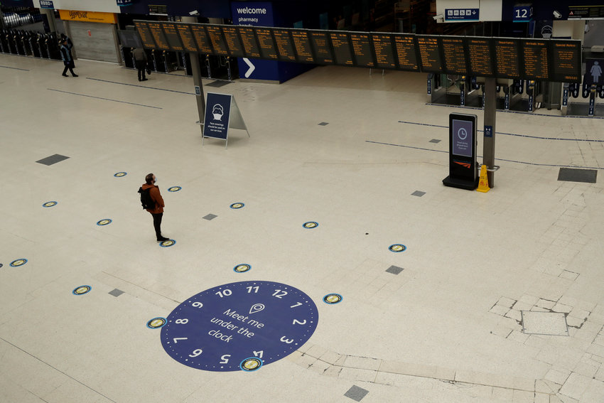 Social distancing signs stand on the floor by train departure information screens to help stop the spread of coronavirus in Waterloo station, London, Thursday, June 4, 2020. Waterloo station, which is the busiest train station in Britain, is still much quieter than normal as most commuters are working from home and not travelling into central London to work in their company offices. (AP Photo/Matt Dunham)..