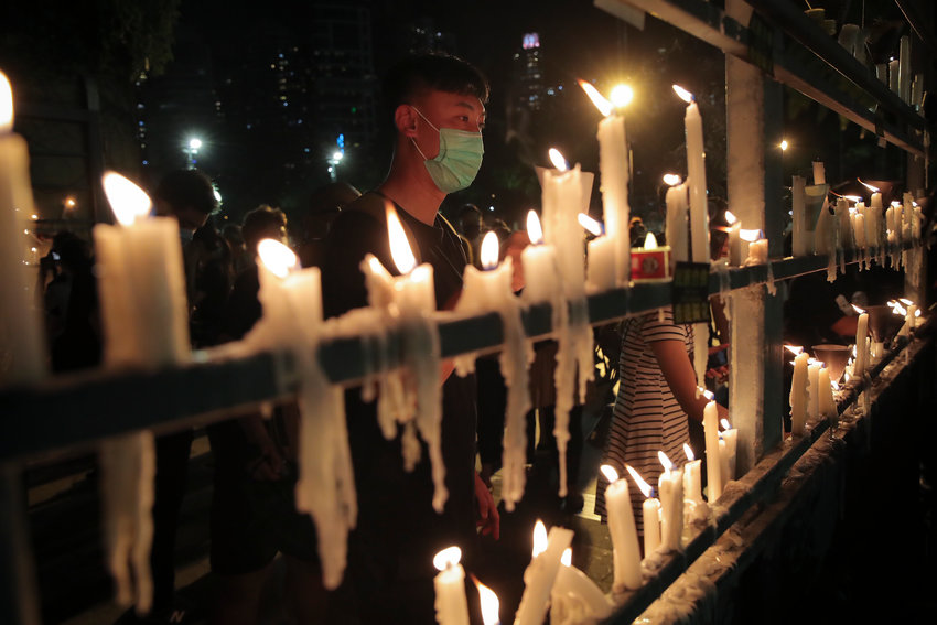 Participants light candles during a vigil for the victims of the 1989 Tiananmen Square Massacre at Victoria Park in Causeway Bay, Hong Kong, Thursday, June 4, 2020, despite applications for it being officially denied. China is tightening controls over dissidents while pro-democracy activists in Hong Kong and elsewhere try to mark the 31st anniversary of the crushing of the pro-democracy movement in Beijing's Tiananmen Square. (AP Photo/Kin Cheung)