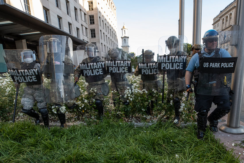 FILE - In this June 1, 2020, file photo, District of Columbia National Guard, and U.S. Park Police, advance through the white roses in front of the AFL-CIO headquarters, with St. John's Church behind them, as they move demonstrators back after they gathered to protest the death of George Floyd near the White House in Washington. The National Guard has designated military police units in two states to serve as rapid reaction forces in order to be better prepared to respond quickly to civil unrest around the country, in the wake of the violent protests that rocked the nation&rsquo;s capitol and several states this summer.  (AP Photo/Alex Brandon, File)