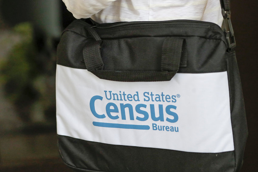 A briefcase of a census taker is seen as she knocks on the door of a residence Tuesday, Aug. 11, 2020, in Winter Park, Fla.  (AP Photo/John Raoux)