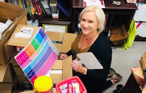 Jasper City Schools curriculum coordinator Kristy Watkins is pictured with some items that will be distributed to students to enhance reading and math skills.
