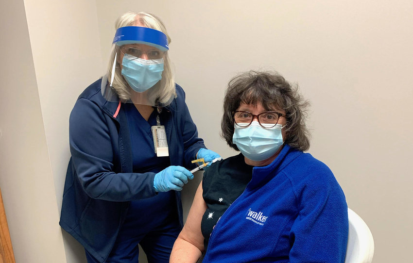 Walker Baptist Medical Center registered nurse Wanda Phillips prepares to administer the Moderna COVID-19 vaccine to respiratory therapist Renee Pruitt.
