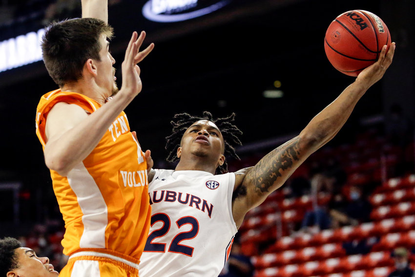 Auburn guard Allen Flanigan (22) puts up a shot around Tennessee forward John Fulkerson (10) during the first half of their game Saturday in Auburn.