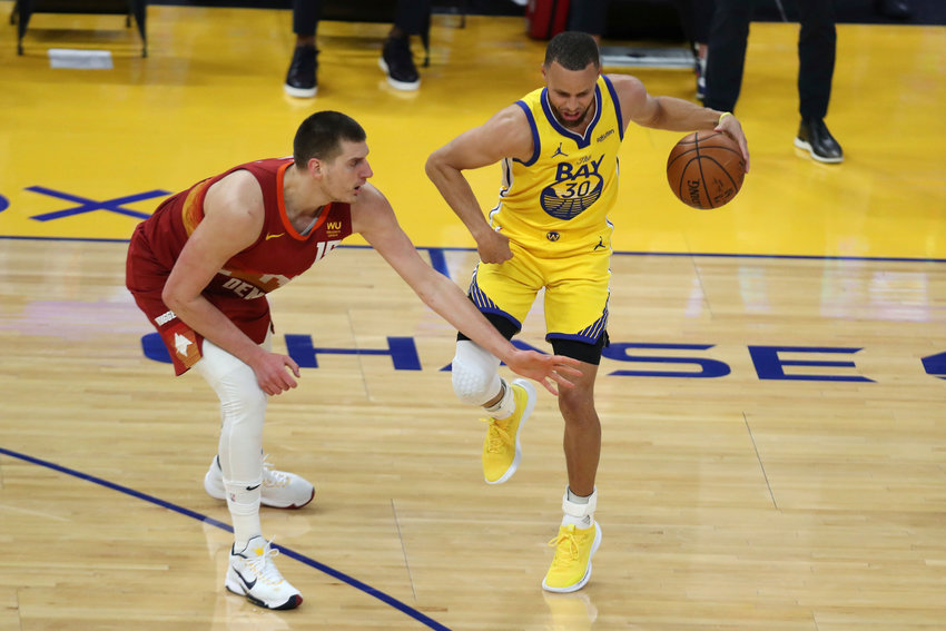 Golden State Warriors' Stephen Curry, right, drives against Denver Nuggets' Nikola Jokic during the first half of an NBA basketball game in San Francisco, Friday, April 23, 2021. (AP Photo/Jed Jacobsohn)