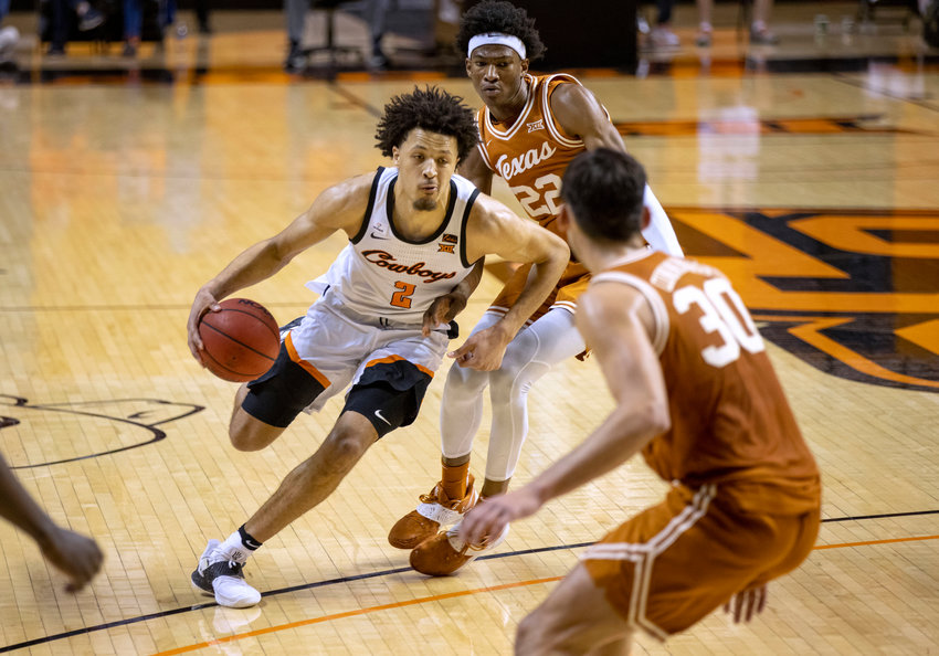 Oklahoma State guard Cade Cunningham (2) drives past Texas forward Kai Jones (22) and Brock Cunningham (30) during the first overtime of the NCAA college basketball in Stillwater, Okla., Saturday, Feb. 6, 2021. (AP Photo/Mitch Alcala)