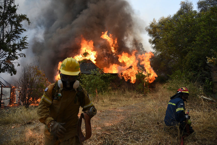 Firefighters operate during a wildfire near Lampiri village, west of Patras, Greece, Saturday, Jul. 31, 2021. The fire, which started high up on a mountain slope, has moved dangerously close to seaside towns and the Fire Service has send a boat to help in a possible evacuation of people. (AP Photo/Andreas Alexopoulos)