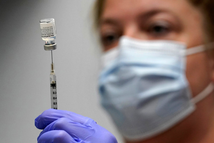 Hollie Maloney, a pharmacy technician, loads a syringe with the Pfizer-BioNTech COVID-19 Vaccine, Tuesday, March 2, 2021, at the Portland Expo in Portland, Maine. (AP Photo/Robert F. Bukaty)