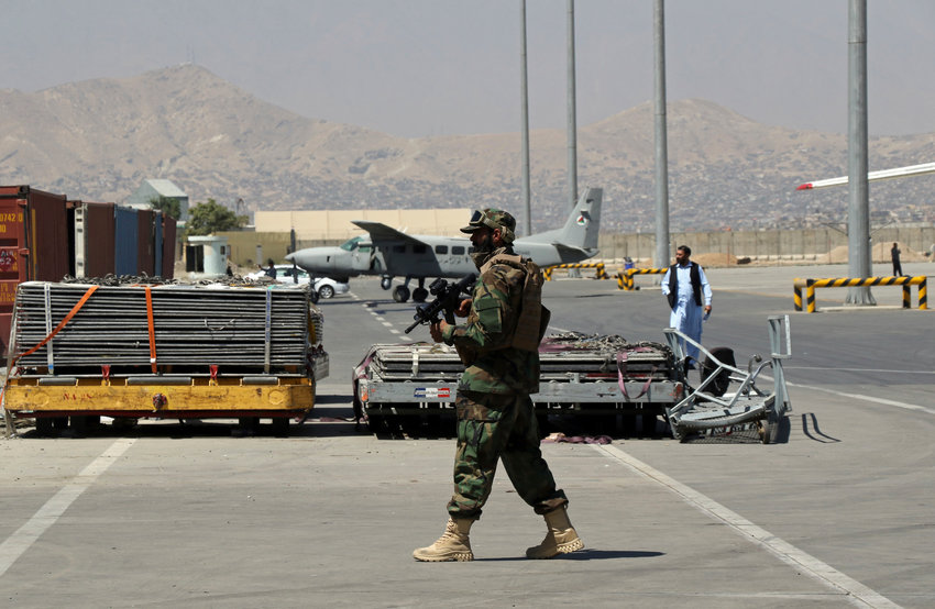 Taliban fighter walks at Hamid Karzai International Airport in Kabul, Afghanistan, Sunday, Sept. 5, 2021. Some domestic flights have resumed at Kabul's airport, with the state-run Ariana Afghan Airline operating flights to three provinces. (AP Photo/Wali Sabawoon)..