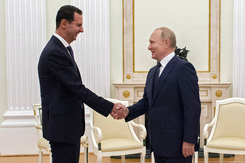 Russian President Vladimir Putin, right, greets Syrian President Bashar Assad during their meeting in the Kremlin in Moscow, Russia, Monday, Sept. 13, 2021. (Mikhail Klimentyev, Sputnik, Kremlin Pool Photo via AP)