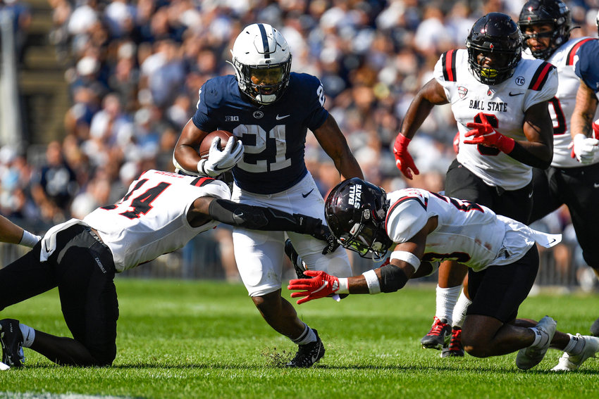 Penn State running back Noah Cain (21) splits two Ball State defenders on a first half run during an NCAA college football game in State College, Pa., on Saturday, Sept. 11, 2021. Penn State defeated Ball State 44-13. (AP Photo/Barry Reeger)