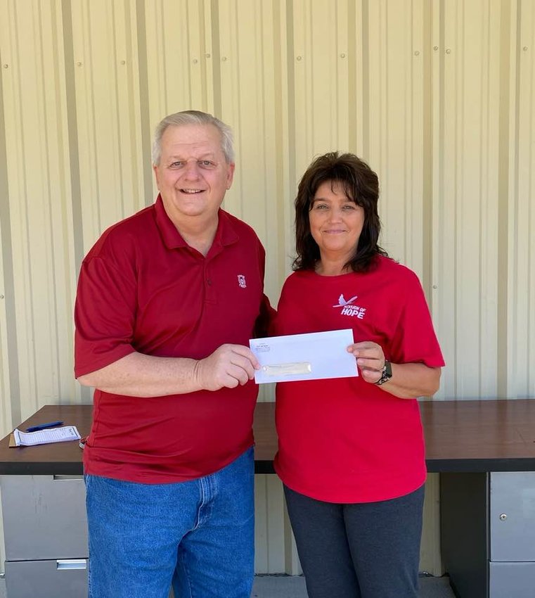 Dora Mayor Randy Stephens presents a $5,000 check to the Mission of Hope recently. The donation came out of the federal funds allotted to the city by the American Rescue Plan Act. Lori Campbell Abercrombie, director of the Mission of Hope accepts the check.