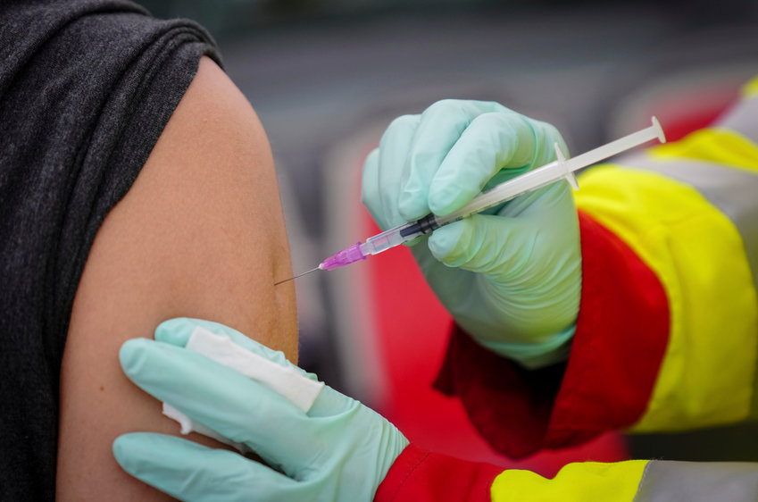 A person is vaccinated with the Pfizer vaccine against the coronavirus and the COVID-19 disease at vaccination bus in Berlin, Germany, Tuesday, Nov. 23, 2021. Germany battles rising numbers of coronavirus infections. (Kay Nietfeld/dpa via AP)