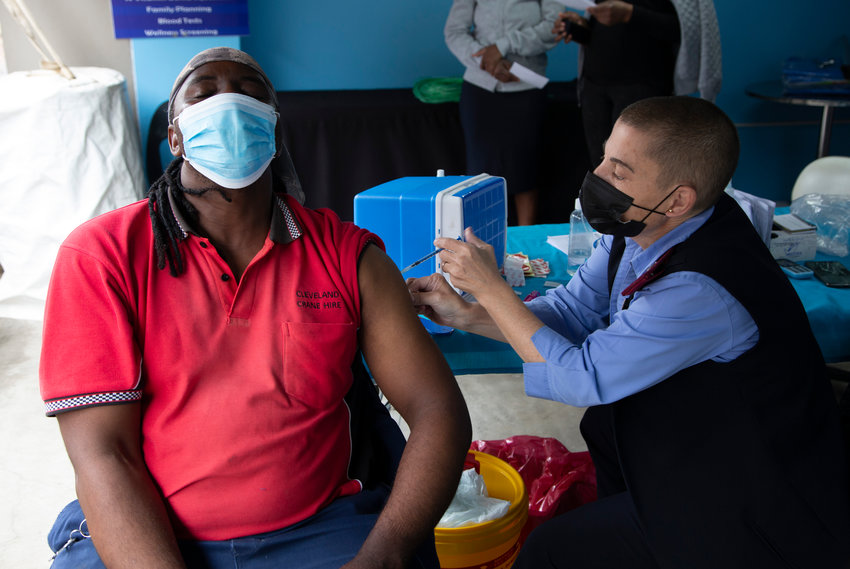 A man gets vaccinated against COVID-19 at a site near Johannesburg, Monday, Dec. 13, 2021. a day after South African President Cyril Ramaphosa tested positive receiving  for mild COVID-19 symptoms after testing positive for the disease.  Ramaphosa started feeling unwell Sunday and a test confirmed COVID-19. A statement said he has mild symptoms, is self-isolating in Cape Town and is being monitored by the South African Military Health Service. (AP Photo/Denis Farrell)