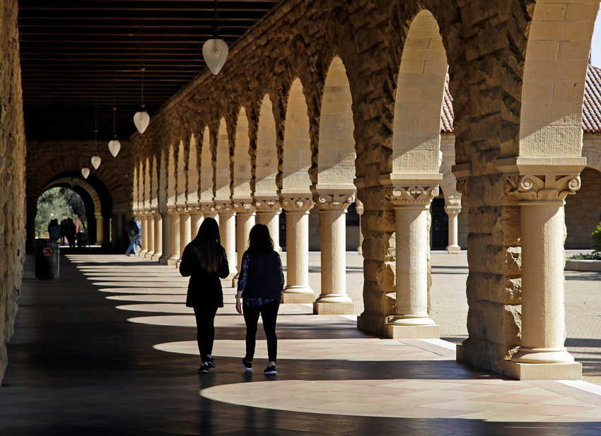 FILE &mdash; Students walk on the Stanford University campus in Stanford, Calif, March 14, 2019. When students at Stanford University return to campus in January 2022, they'll be barred from holding parties or other big gatherings for two weeks. (AP Photo/Ben Margot, File)