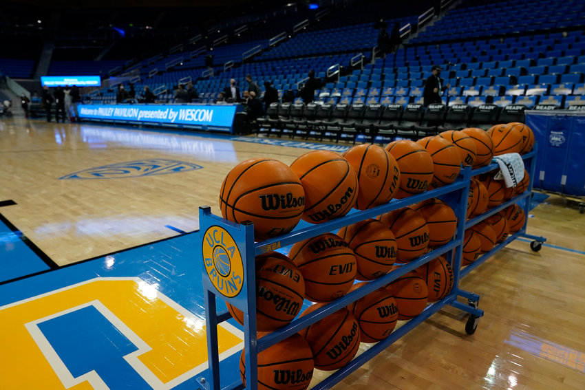 Basketballs are stacked on the baseline before an NCAA college basketball game between UCLA and Alabama State Wednesday, Dec. 15, 2021, in Los Angeles. The game will not be played due to COVID-19 protocols. (AP Photo/Marcio Jose Sanchez)