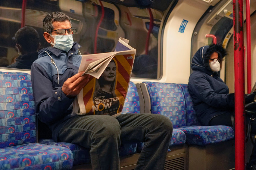 A man wears a face mask as he read a newspaper on a London Underground train, in London, Thursday, Dec. 16, 2021. The U.K. recorded the highest number of confirmed new COVID-19 infections Wednesday since the pandemic began, and England&rsquo;s chief medical officer warned the situation is likely to get worse as the omicron variant drives a new wave of illness during the Christmas holidays. The U.K. recorded 78,610 new infections on Wednesday, 16% higher than the previous record set in January.(AP Photo/Alberto Pezzali)