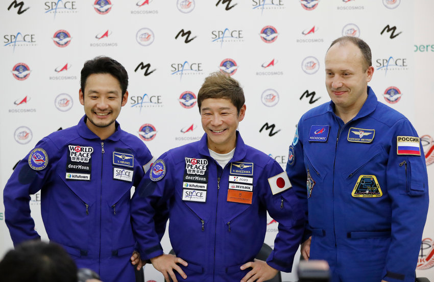 FILE - Roscosmos cosmonaut Alexander Misurkin, right, space flight participants Yusaku Maezawa, center, and Yozo Hirano attend a news conference ahead of the expedition to the International Space Station at the Gagarin Cosmonauts' Training Center in Star City outside Moscow, Russia, Oct. 14, 2021. During an interview with the Associated Press on Monday, Dec. 13, 2021, Maezawa said he experienced motion sickness after arriving at the space outpost and it took him a few days to adapt to zero gravity. (Shamil Zhumatov/Pool Photo via AP)