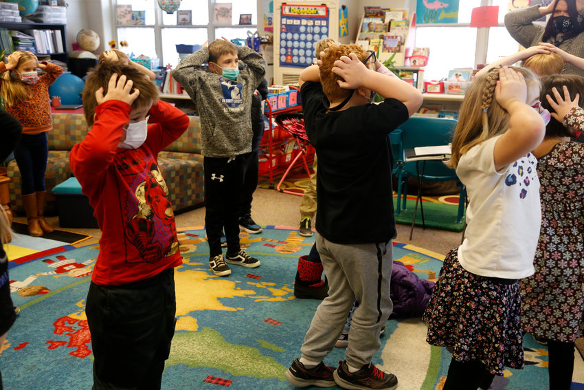 Second-graders hold their heads as they talk about &quot;thoughts&quot; and how they compare with &quot;feelings&quot; and resulting &quot;actions,&quot; at Paw Paw Elementary School on Thursday, Dec. 2, 2021, in Paw Paw, Michigan. Their teacher is one of many in the school trained to use a curriculum created at the University of Michigan called TRAILS. Research suggests TRAILS lessons for at-risk kids can reduce depression and improve coping skills &mdash; something district officials say has been particularly important during the pandemic. (AP Photo/Martha Irvine)