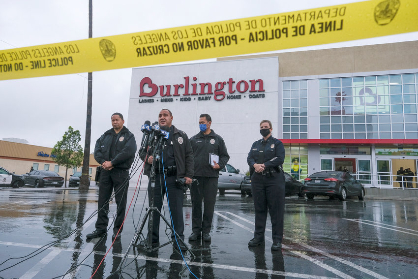 Los Angeles Police Department PIO Capt. Stacy Spell, second from left, speaks in a press conference at the scene where two people were struck by gunfire in a shooting at the Burlington Coat Factory store in North Hollywood, Calif., Thursday, Dec. 23, 2021. (AP Photo/Ringo H.W. Chiu).