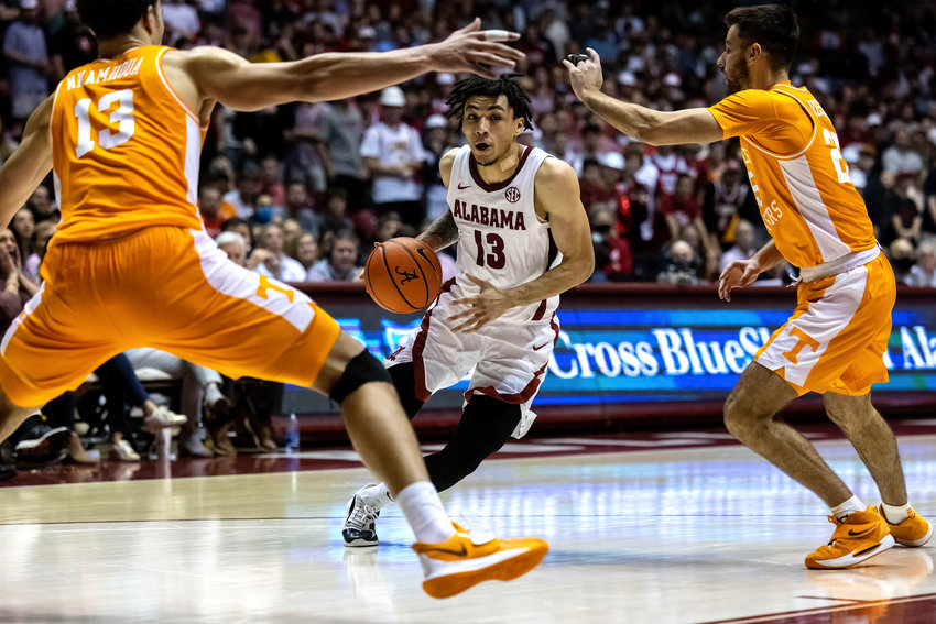 Alabama guard Jahvon Quinerly (13) works inside against Tennessee forward Olivier Nkamhoua (13) and guard Santiago Vescovi (25) during the second half of an their game Wednesday, in Tuscaloosa.