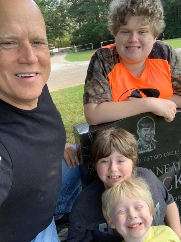 Stephen Aycock of Jasper and his three living children gather at the grave of his son, Ryan. Aycock is forming a support group for parents dealing with the death of their children.