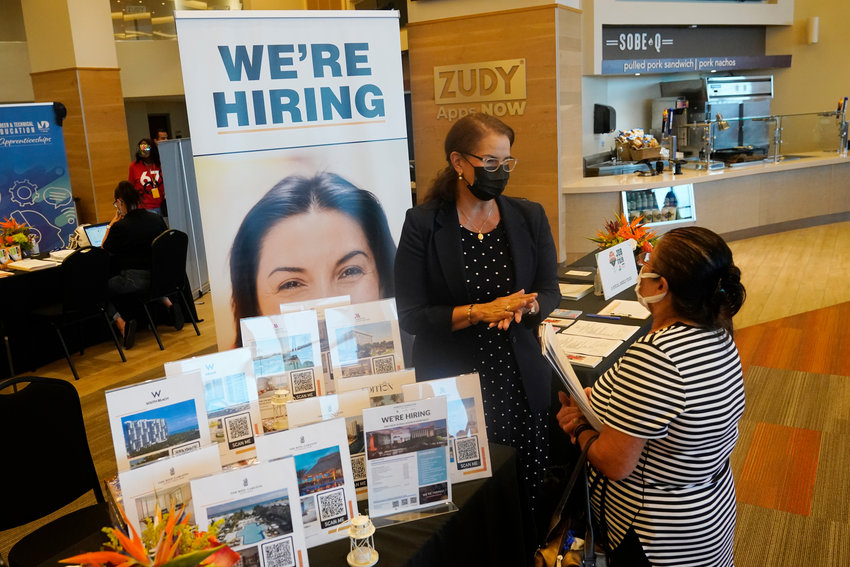 FILE - Marriott human resources recruiter Mariela Cuevas, left, talks to Lisbet Oliveros, during a job fair at Hard Rock Stadium, Friday, Sept. 3, 2021, in Miami Gardens, Fla.  Last month, U.S. employers might have shed jobs for the first time in about a year, potentially raising alarms about the economy&rsquo;s trajectory. Yet even if the January employment report coming Friday, Feb. 3, 2022, were to show a deep loss of jobs, there would be little mystery about the likely culprit: A wave of omicron wave of infections that led millions of workers to stay home sick, discouraged consumers from venturing out to spend and likely froze hiring at many companies &mdash; even those that want to fill jobs.  (AP Photo/Marta Lavandier, File)