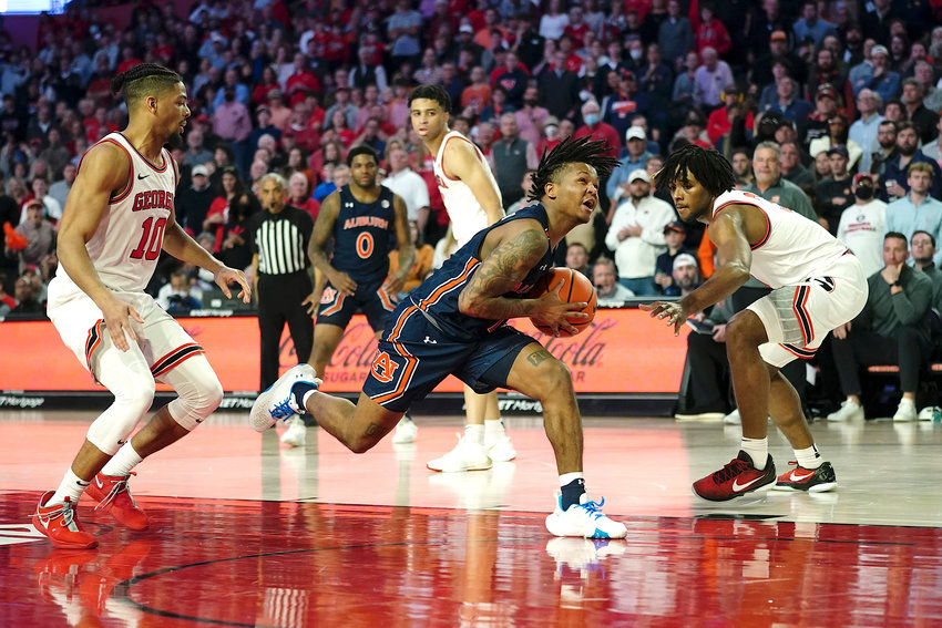 Auburn guard Wendell Green Jr. (1) drives between Georgia's Aaron Cook (10) and Kario Oquendo (3) during the second half of an NCAA college basketball game Saturday, Feb. 5, 2022, in Athens, Ga. (AP Photo/John Bazemore)
