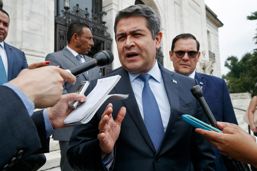 Honduran President Juan Orlando Hernandez answers questions from the Associated Press, Tuesday, Aug. 13, 2019, as he leaves a meeting at the Organization of American States, in Washington. (AP Photo/Jacquelyn Martin)
