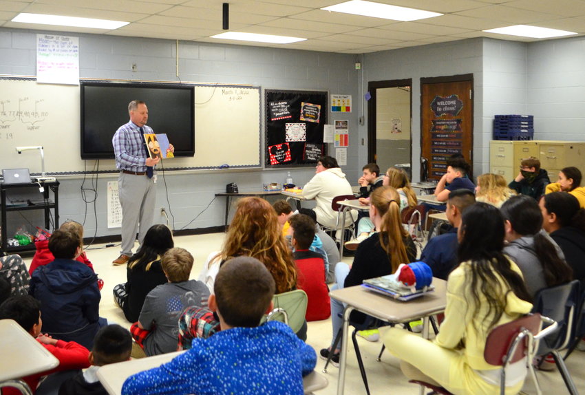 Many people in Walker County have read to students at schools this week to observe Read Across America. Pictured is Tim Hulsey of the Walker County Schools central office reading to a group of sixth-grade students at Valley Jr. High School.