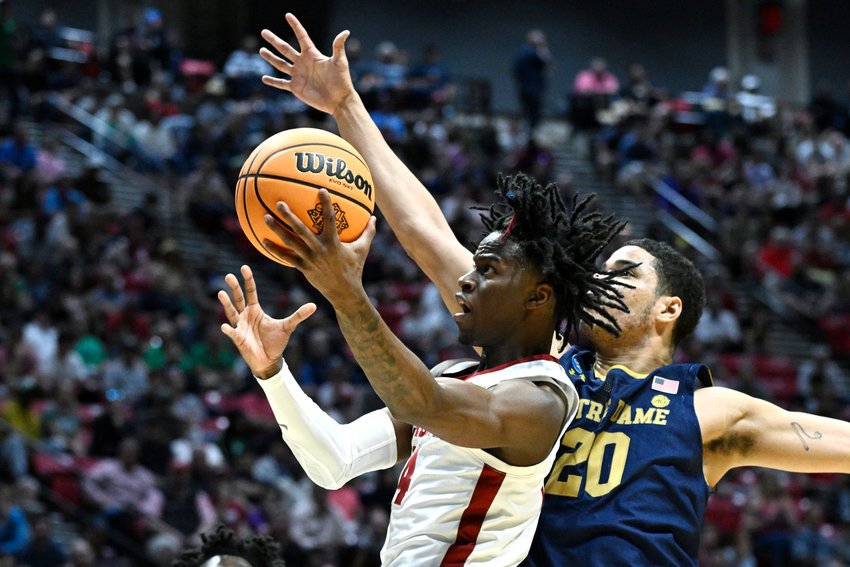 Alabama guard Keon Ellis (14) drives to the basket in front of Notre Dame forward Paul Atkinson Jr. (20) during the first half of a first-round NCAA college basketball tournament game, Friday, March 18, 2022, in San Diego. (AP Photo/Denis Poroy)