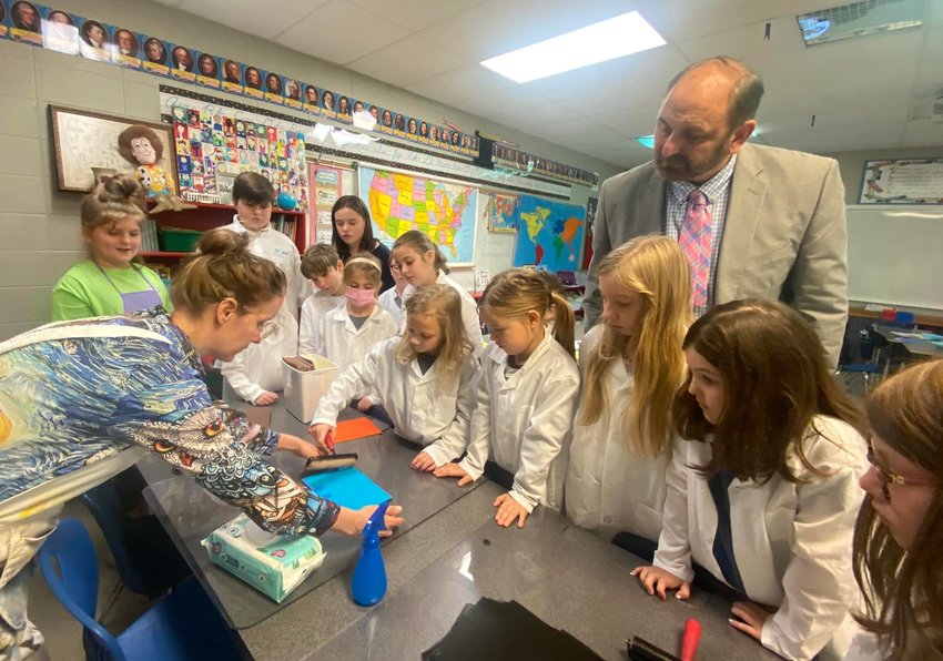 Tabatha Lendquvist-Grace of the Walker County Arts Alliance leads a visual arts program for third graders in county schools. Walker County Schools Superintendent Dr. Dennis Willingham and students observe while receiving instructions for an art project.