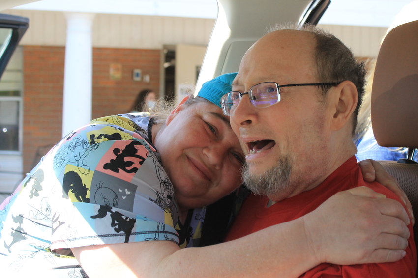 Timothy Mitchell receives a congratulatory hug outside Cordova Health and Rehabilitation on Tuesday, April 26. Mitchell went home 16 months after going into the hospital with COVID-19 and eight months after transferring to the nursing home.