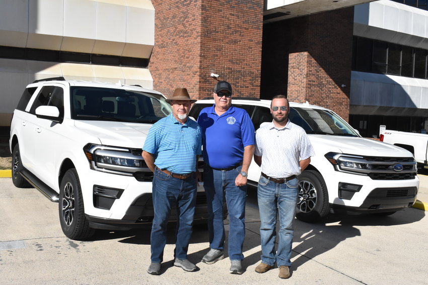 Walker County Coroner Joey Vick, left, Walker County Commission Chairman Steve Miller, center and Assistant Coroner Frankie Poston show off the two new Ford Expedition vehicles purchased for the Coroner's Office using a grant. The vehicles were picked up on Monday.