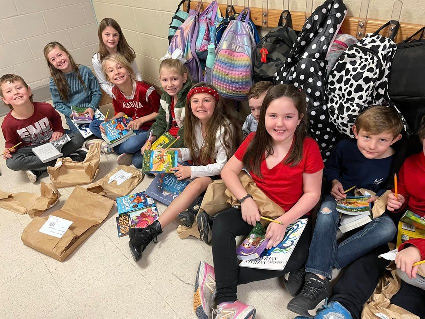 Students at Curry Elementary open up the books they received as part of the school's Book Blast.