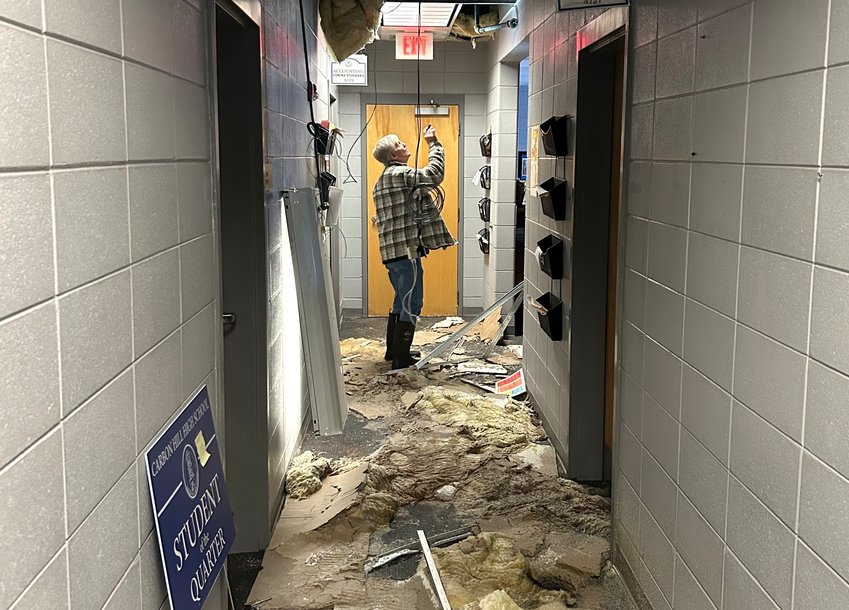 A maintenance employee of the Walker County school system examines the water damage at Carbon Hill High School that was caused by busted pipes in the sprinkler system.
