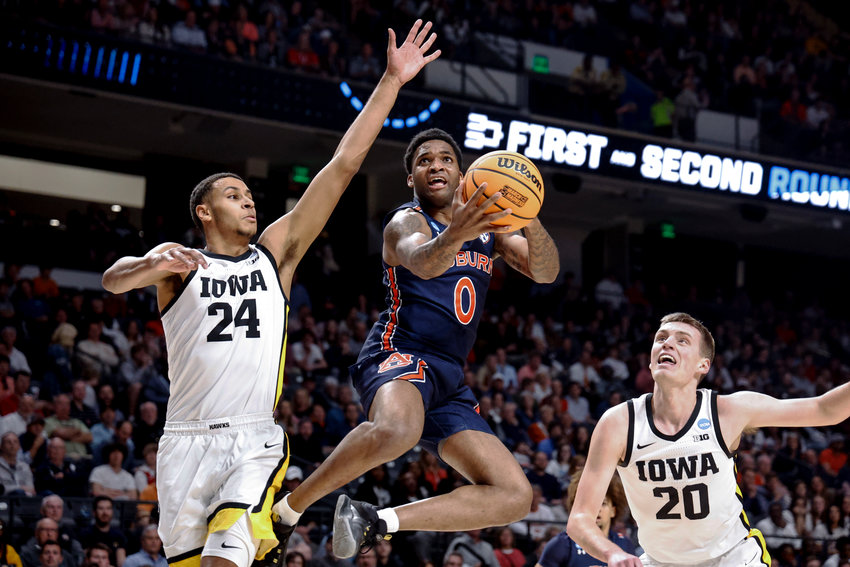 Auburn guard K.D. Johnson (0) shoots around Iowa forward Kris Murray (24) during the first half of a first-round college basketball game in the men's NCAA Tournament in Birmingham, Ala., Thursday, March 16, 2023. (AP Photo/Butch Dill)