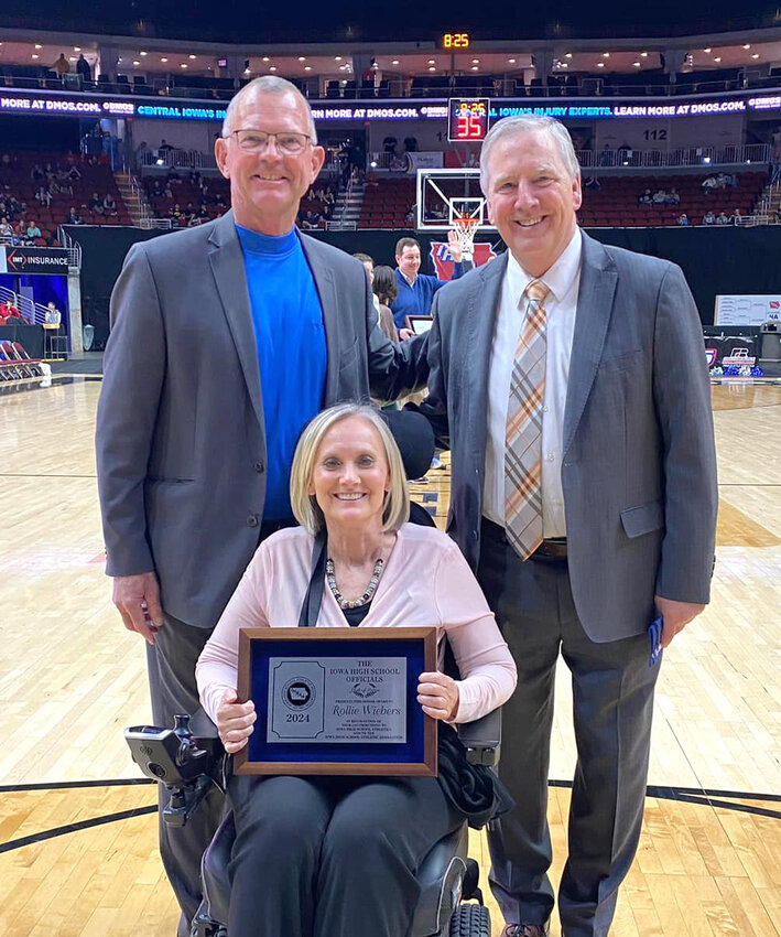 Former Charter Oak-Ute Superintendent Rollie Wiebers was inducted to the IHSAA Officials Hall of Fame. He was honored during the 2025 IHSAA State Basketball Tournament on Friday, March 14. .Pictured with Wiebers is Cheryl Krohnke and Tom Keating, Executive Director of the IHSAA.