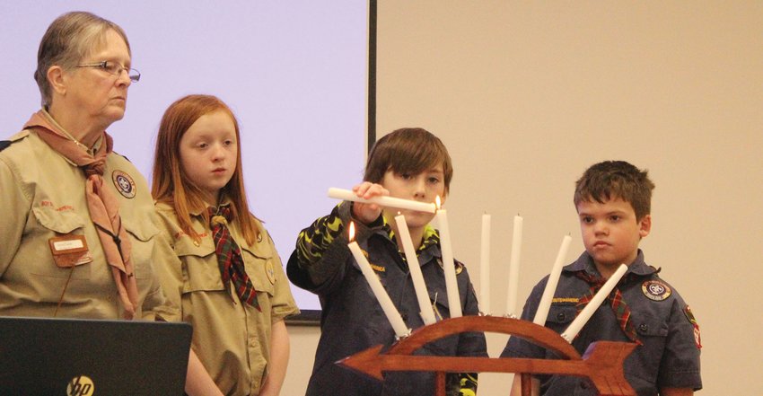 Alekz Matts lights a candle during the Arrow of Light Ceremony at the 2022 Missouri Valley Blue and Gold Banquet.