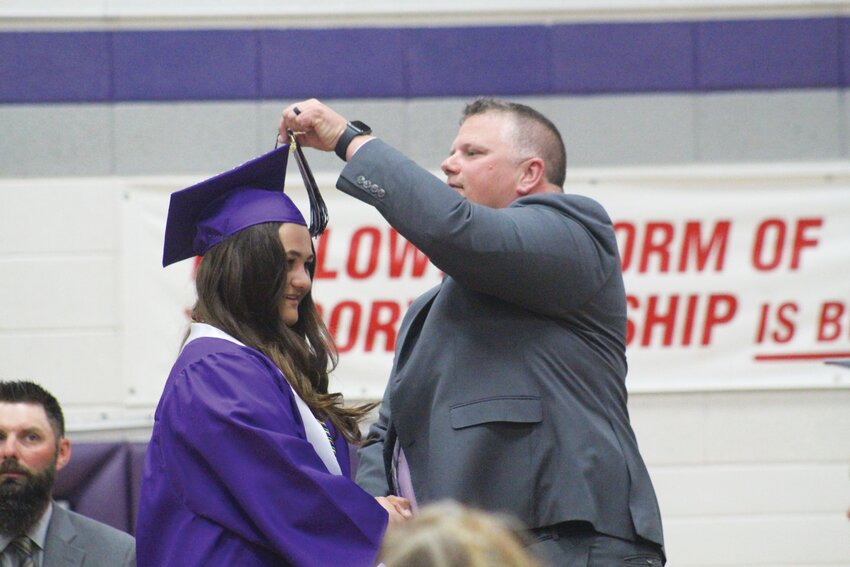 Superintendent Jeremy Christiansen moves Lisa Renner's tassle from one side to the other.