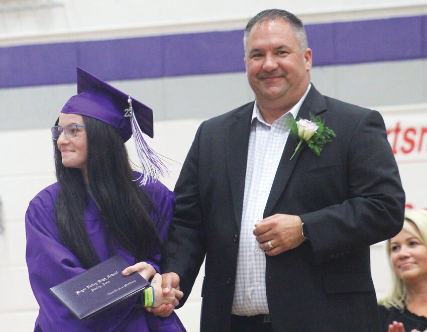 Graci Mahlberg proudly glances at her family while receiving her diploma from Board of Education President Steven Puck.
