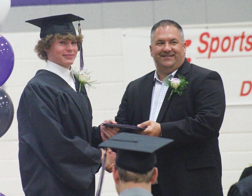 Jackson Anderson receives his diploma from Board of Education President Steven Puck.