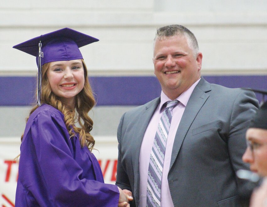 Reagan Harris smiles as she shakes hands with Boyer Valley Superintendent Jeremy Christiansen.
