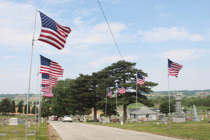 An avenue of flags leads up to the American Legion memorial at the cemetery.