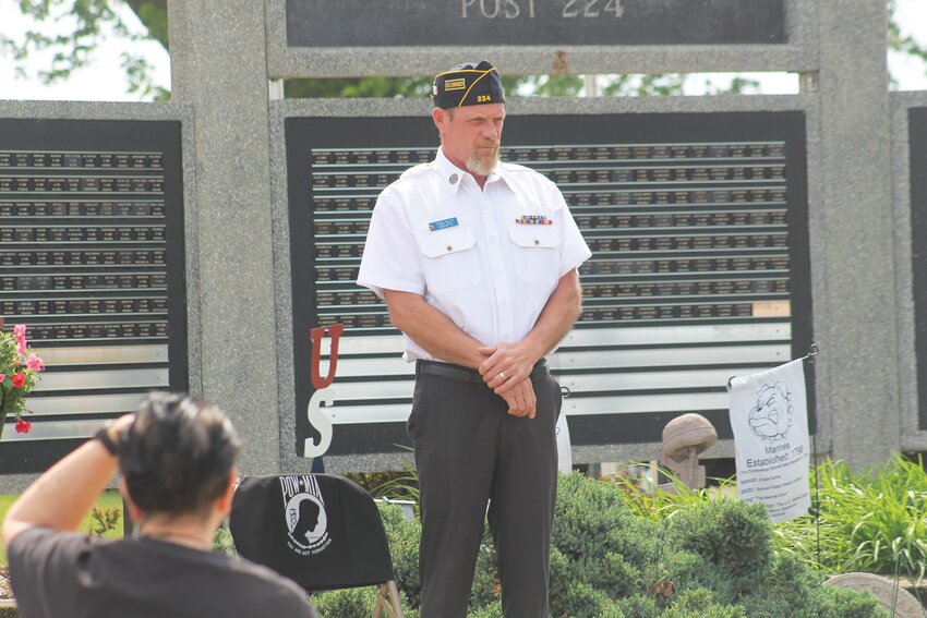 Vice Commander Craig Miller stands next to the vacant seat reserved for those who are prisoners of war or missing in action.