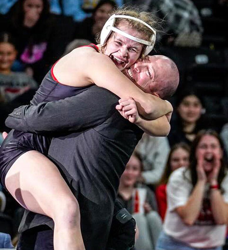 Missouri Valley's Nikki Olson is embraced by her head coach, Keefer Jensen, moments after celebrating the 2024 Girls State Wrestling Championship.