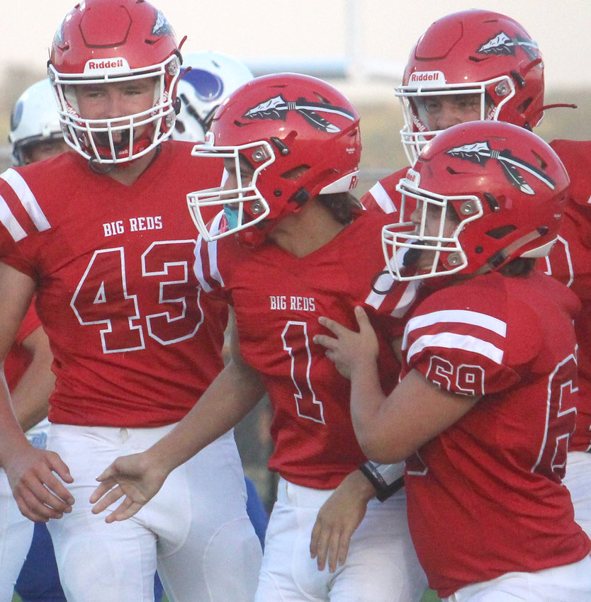 Missouri Valley's Gage Clausen (43) and Tony Sargent (69) celebrate with Alex Murray (1) after their first quarter touchdown in the Sept. 4 home opener for the Big Reds.