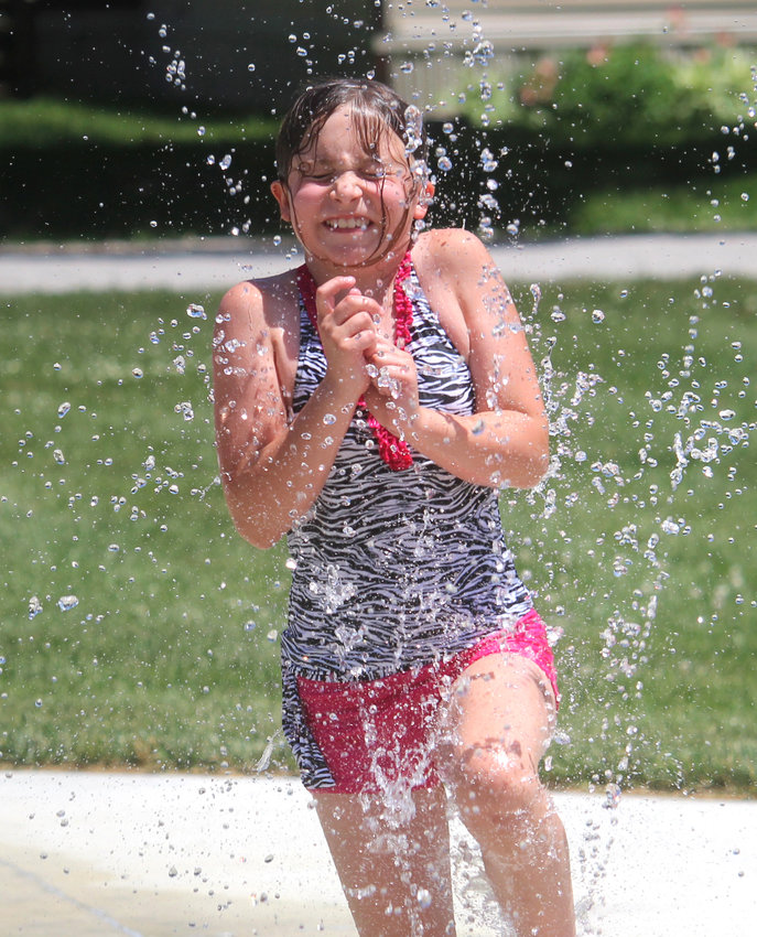 Callie Muldoon enjoys a cool splash on a warm Saturday afternoon at the Mondamin Splash Pad.