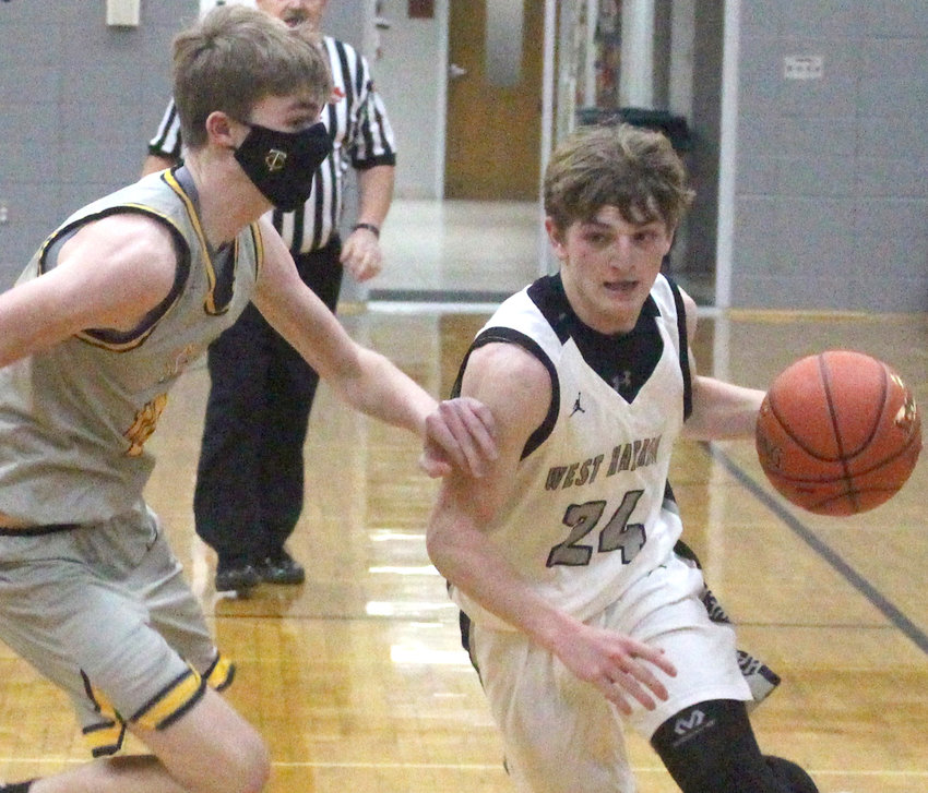 West Harrison's Walker Rife (24) drives around his opponent in a non-conference battle with Tri-Center on Dec. 7 in Mondamin.