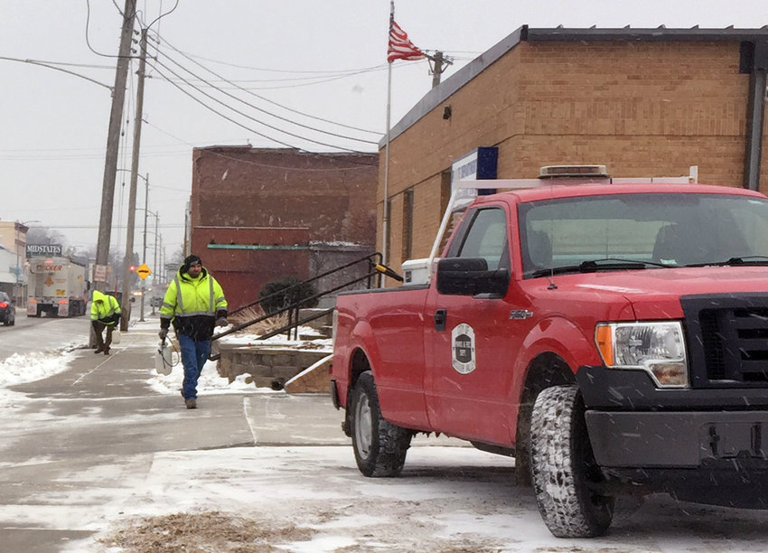 Missouri Valley Street crews prepared for the anticipated snow event early Monday morning. Here, two City employees spray an ice blocking agent on the sidewalk in front of the Missouri Valley Police Department.
